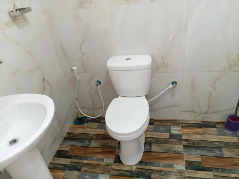 En-suite bathroom with marble-effect wall tiles and a western toilet