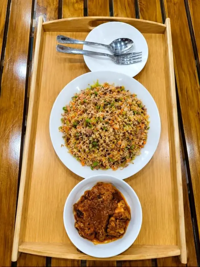 Fried rice with chicken curry served on a wooden tray