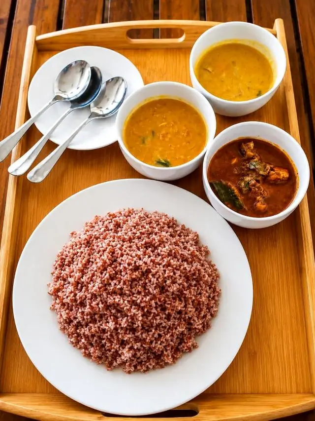 Red rice with dhal and curries on a wooden tray