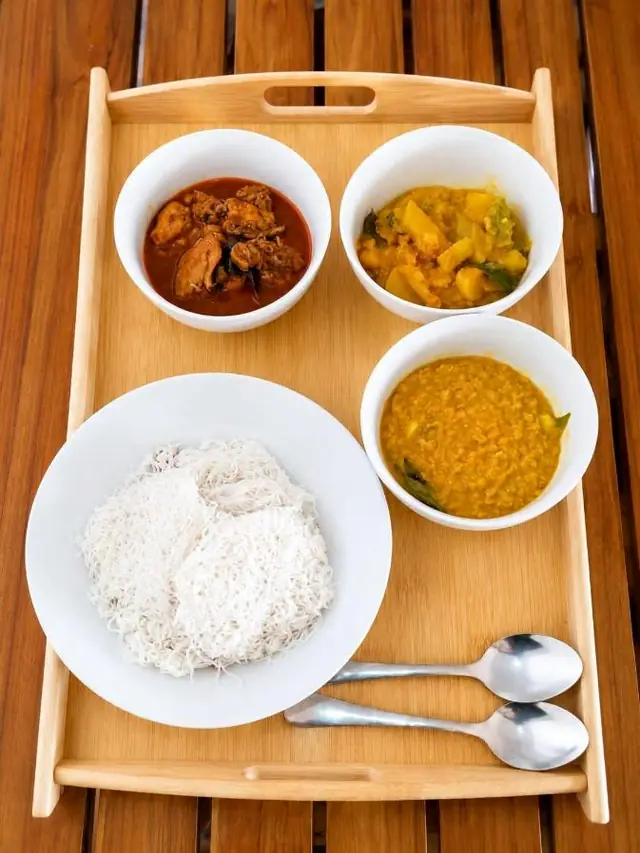Tray of rice with several curries and sambol