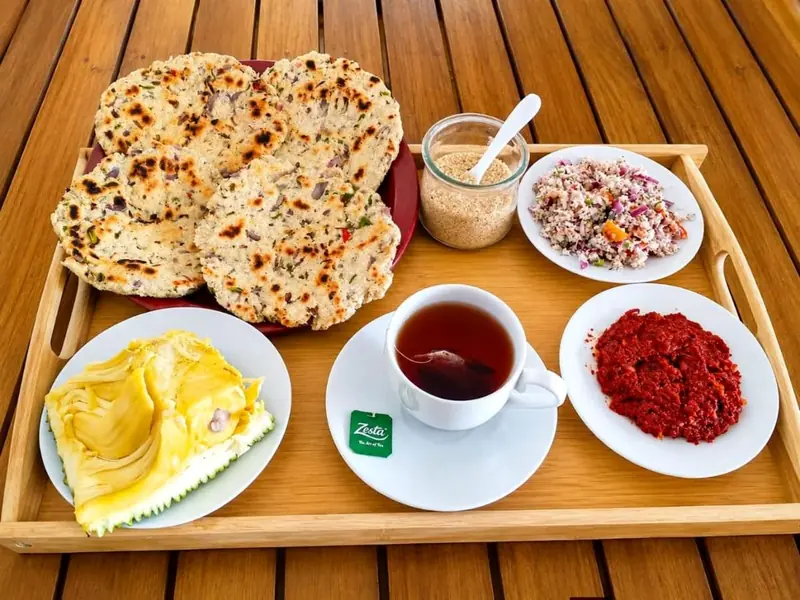 Breakfast tray with coconut roti, fresh pineapple, sambol and a cup of tea