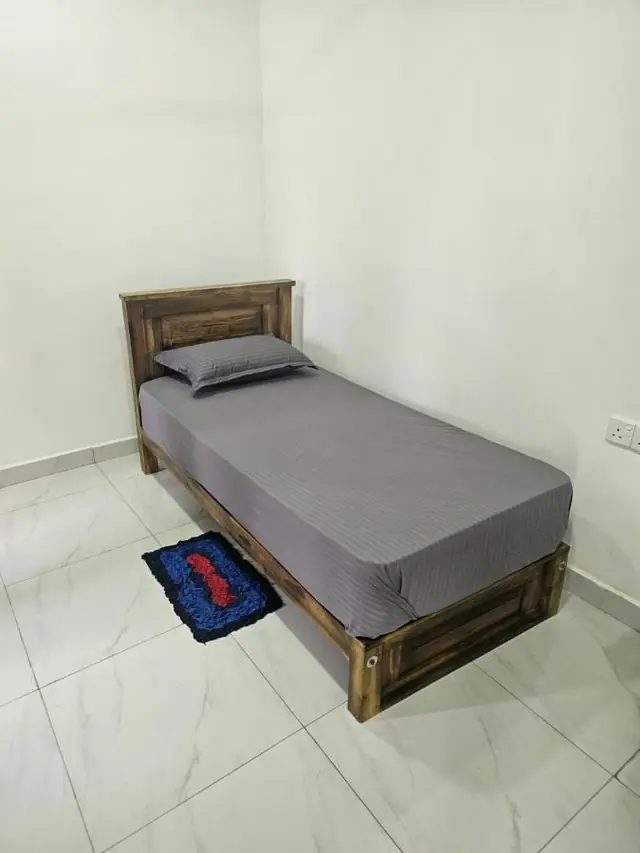 Compact single room with a wooden bed and tiled floor