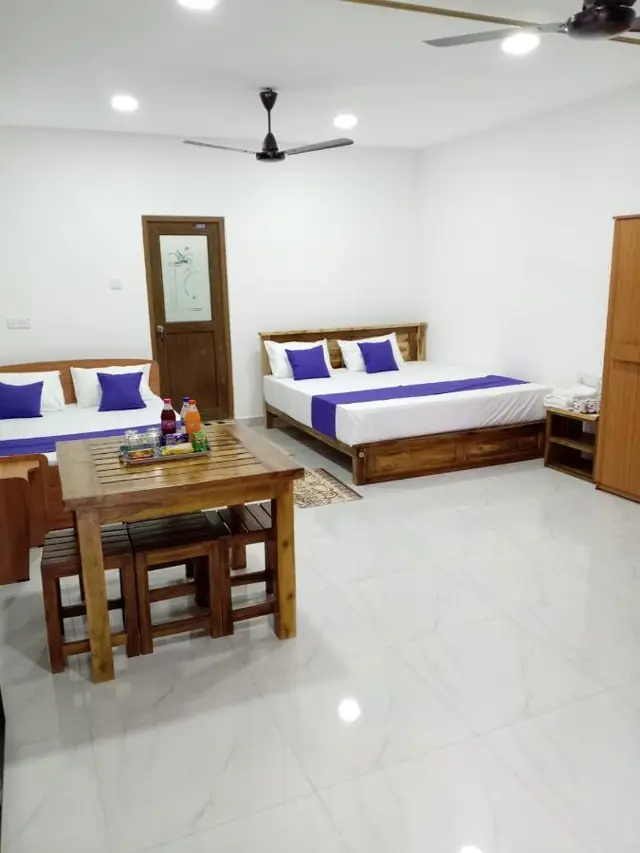 Suite seating area with a wooden table and chairs beside the beds