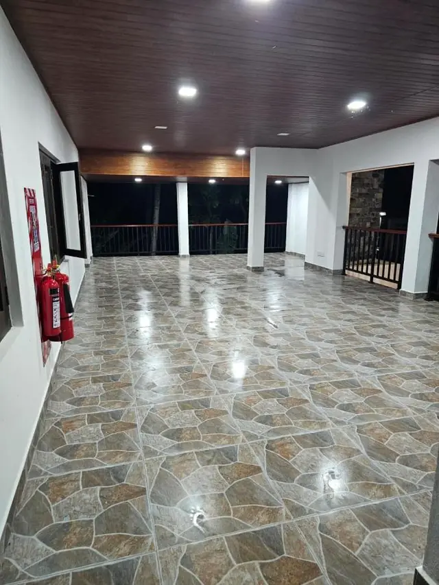 Wide upper-floor hall with tiled floor and balcony railings